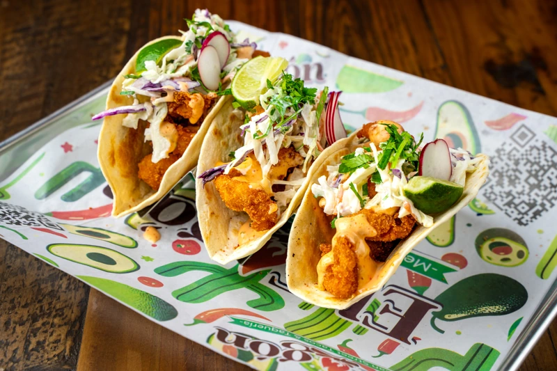 Bang Bang Shrimp taco with creamy spicy sauce from El Fogón Taquería.